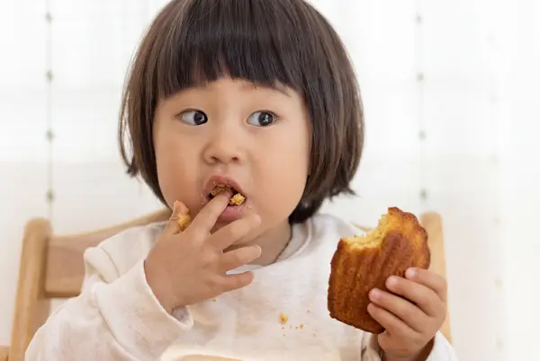 お菓子を頬張る子ども